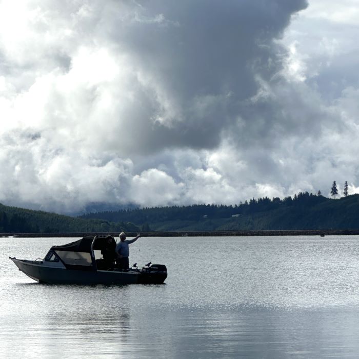 An angler casts off from a boat on Hagg Lake